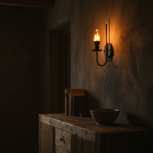 Ampoule à flamme vacillante dans une applique noire sur un mur en plâtre, le soir