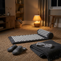 Tapis d'acupression, chaussons chauffants et bandeau audio sur un tapis en jute, le soir